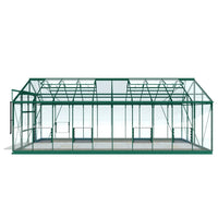 A green, rectangular Rhino Greenhouse with transparent panels stands on a light background. It has a gabled roof and sliding doors on the side, suitable for gardening use.
